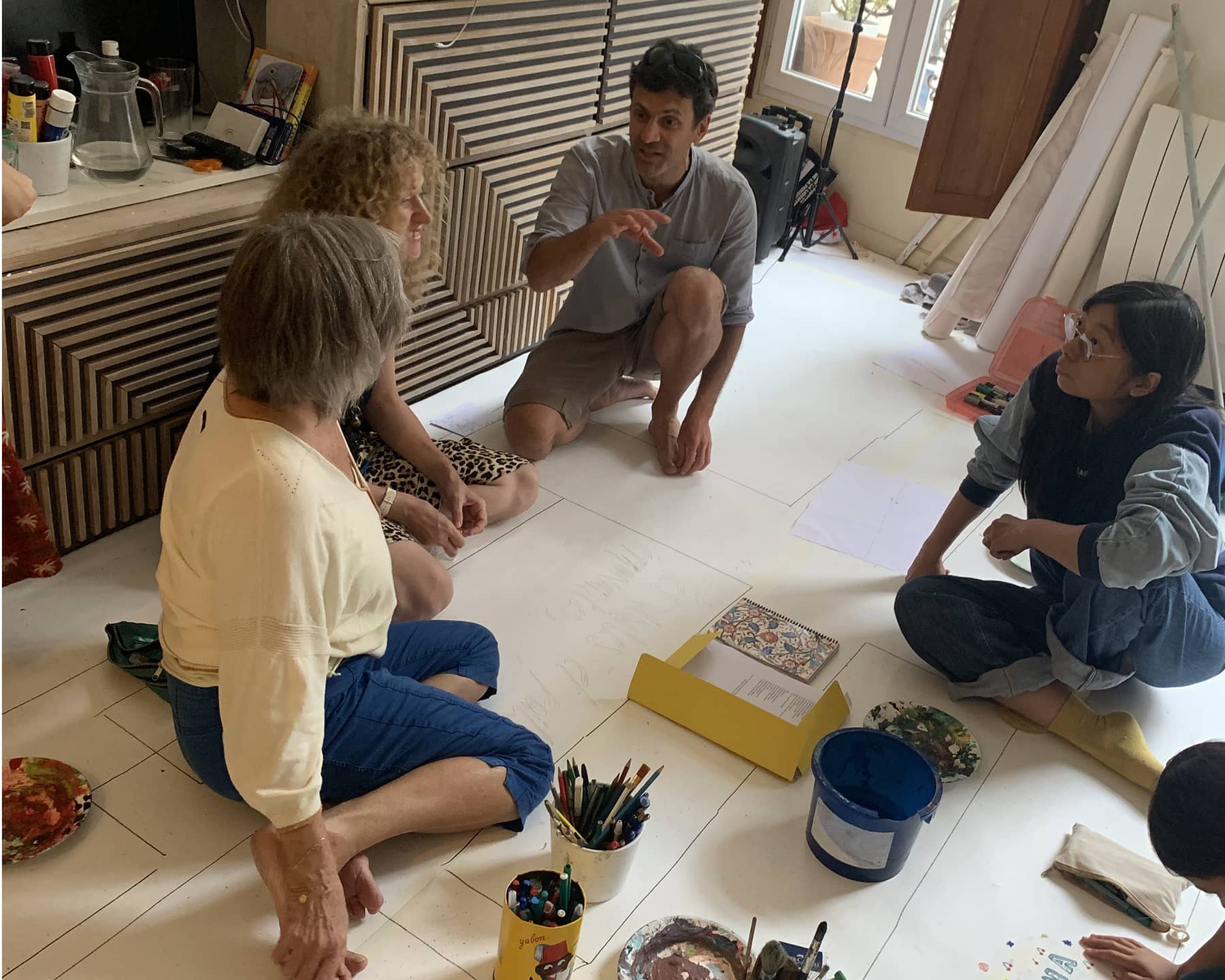 Échange entre partenaires professionnels, ils sont assis par terre en petit comité 